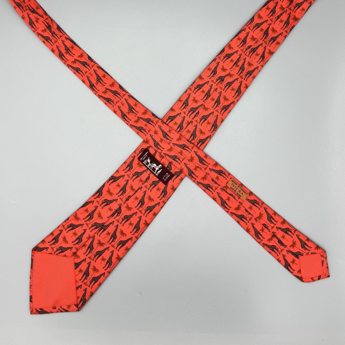 Cravate Hermès corail à motif girafe et palmier - Le Beau Gustave