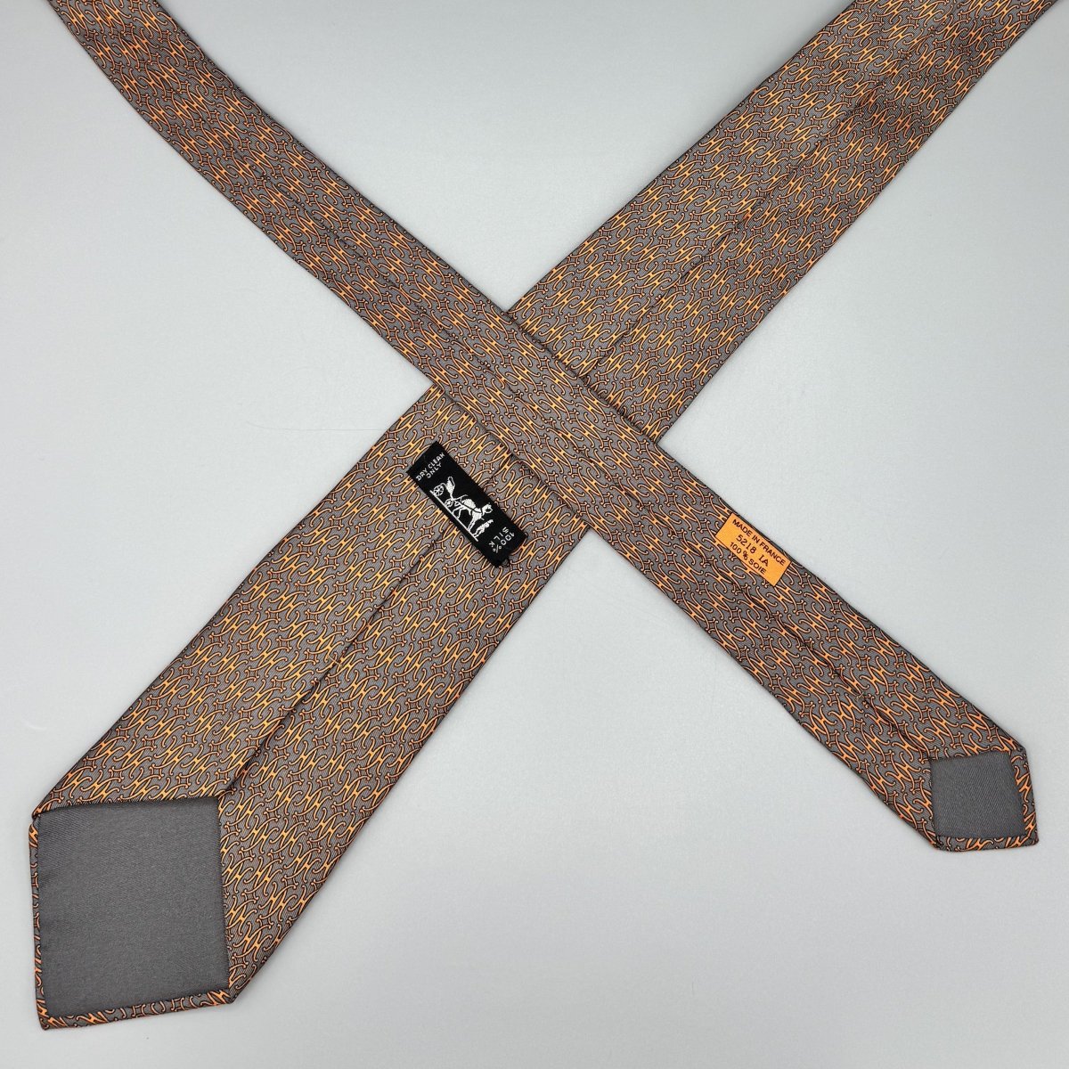 Cravate Hermès grise à motif H orange - Le Beau Gustave