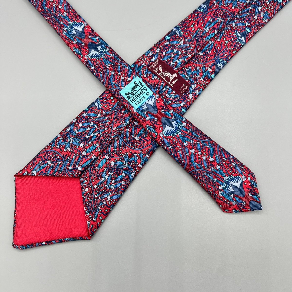 Cravate Hermès rouge à motif floral bleu - Le Beau Gustave