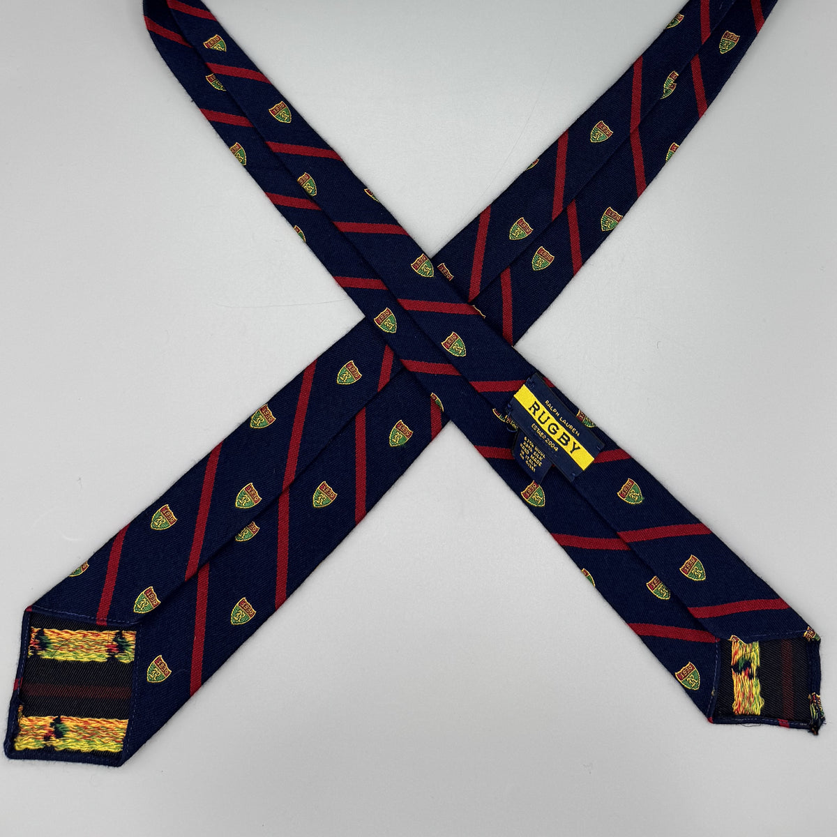 Cravate Rugby Ralph Lauren bleu marine à rayures rouges et motif écusson